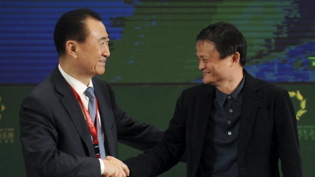 Wang Jianlin (left), chairman of Dalian Wanda Group, shakes hands with Jack Ma, executive chairman of Alibaba Group.