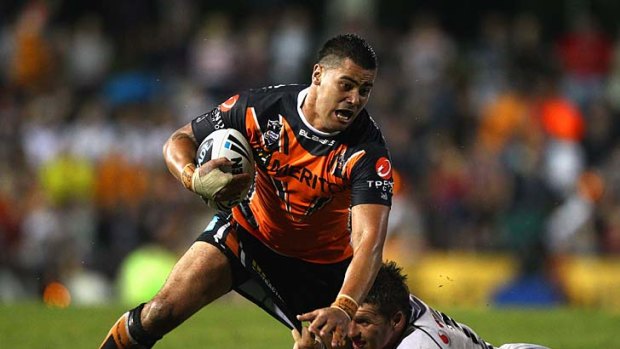 Andrew Fifita of the Tigers is tackled by Brett Seymour of the Warriors.