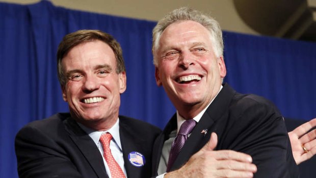Senator Mark Warner, left, smiles and hugs Virginia Democratic Governor-elect Terry McAuliffe, during an election night party in Tysons Corner, Virginia.