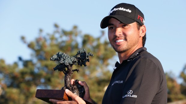 Jason Day poses with the championship trophy after his victory at the Farmers Insurance Open at Torrey Pines.
