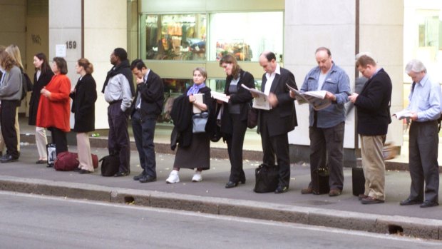 Commuters queue at a bus stop in the CBD.