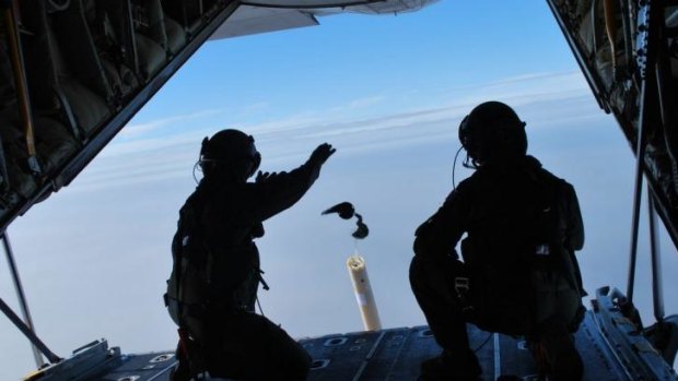 Loadmasters Sergeant Adam Roberts (left) and Flight Sergeant John Mancey launch one of two water-activated buoys from the Hercules C-130J.