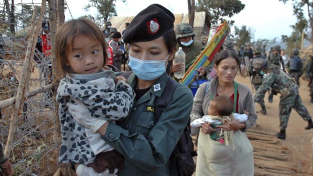 A Thai policewoman holds a Hmong child refugee at the Ban Huay Nam Khao camp in Phetchabun province.