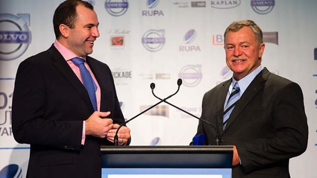 Mark Cummins (right) accepts the Medal of Excellence on behalf of his son Nick Cummins during the Rugby Union Players Association awards lunch in Sydney on Wednesday.