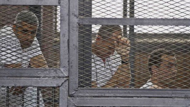 Facing terror charges ... from left, Mohammed Fahmy, Canadian-Egyptian acting bureau chief of Al-Jazeera, Australian correspondent Peter Greste and Egyptian producer Baher Mohamed appear in a defendants' cage during their trial.