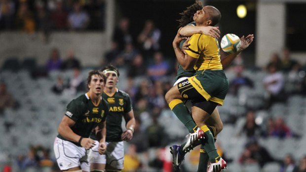 The Springboks' Zane Kirchner collides with the Wallabies' Will Genia as they battle for a high ball.