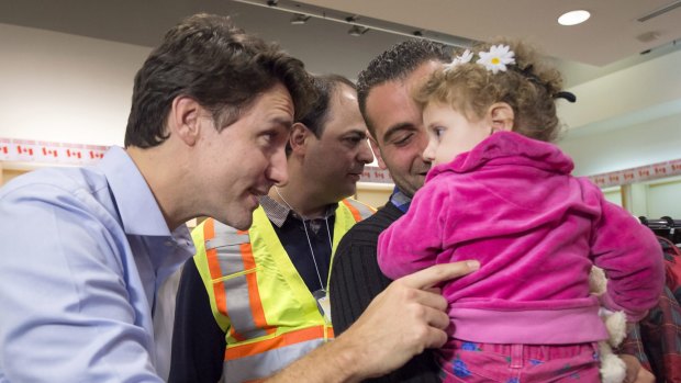 Photo op: Canadian Prime Minister Justin Trudeau, left, greets refugees fleeing Syria, during their arrival in Toronto.