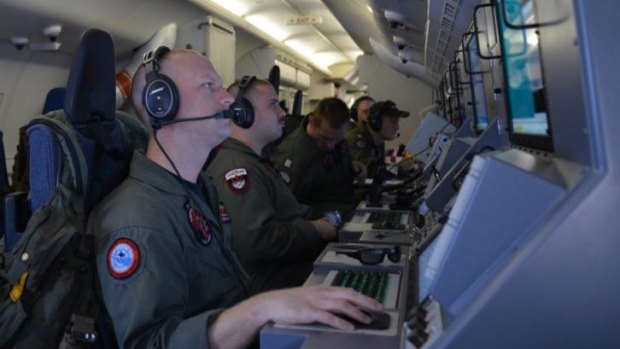 Crew members on board a US Navy P-8A Poseidon assist in search and rescue operations for Malaysia Airlines flight MH370 in the Indian Ocean on Sunday.