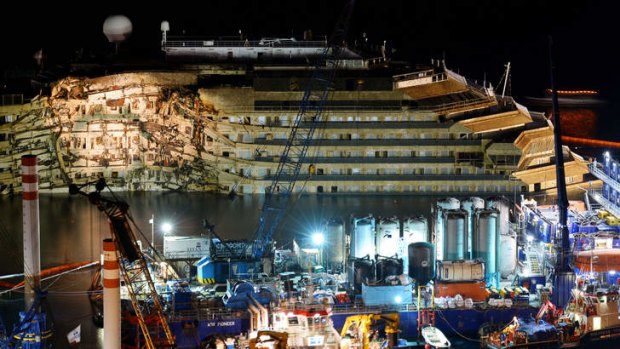 The wreck of Italy's Costa Concordia cruise ship emerges from water near the harbour of Giglio Porto.