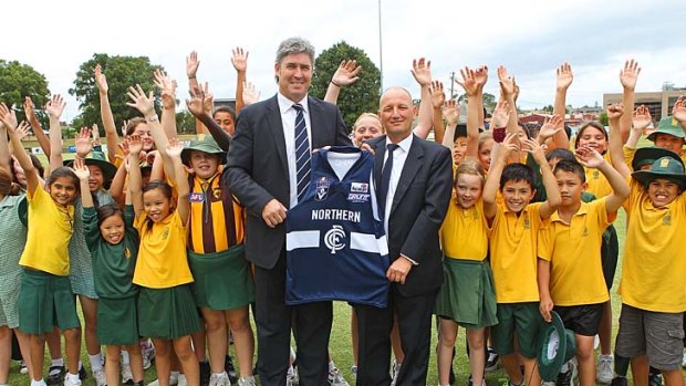 Carlton president Stephen Kernahan and Northern Blues president Stephen Papal hold the  Northern Blues guernsey as they pose with local schoolchildren during the launch of the Northern Blues yesterday.