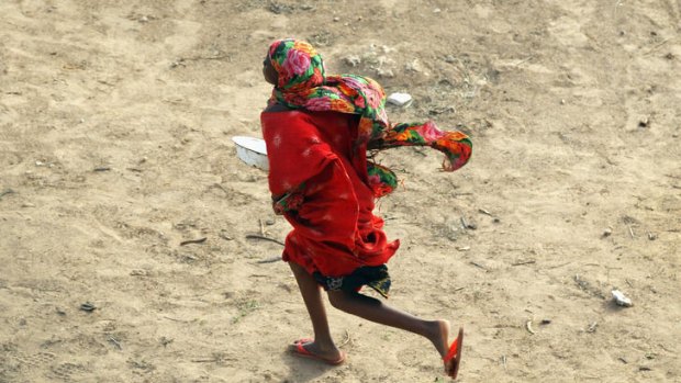 A girls runs to get in line for a cooked meal at a camp for Somalis displaced by drought and famine.