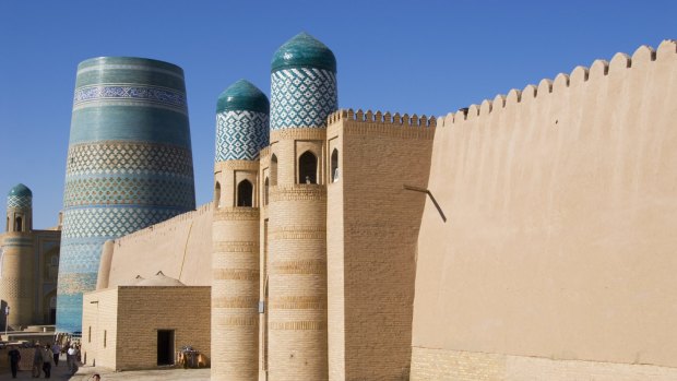 The Kukhana Ark fortress in front of the turquoise-tiled Kalta Minor Minaret in Ichon-Qala in Uzbekistan, Central Asia.