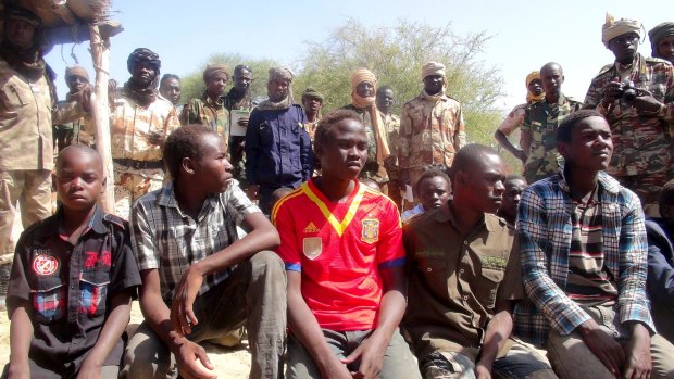 Former members of insurgent group Boko Haram gather in front of Chadian soldiers in Ngouboua, Chad in April.