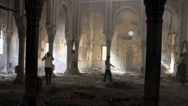 Egyptians walk among the burned remains of the Rabaah al-Adawiya mosque, in the centre of the largest protest camp of supporters of ousted President Mohamed Mursi, that was cleared by security forces.