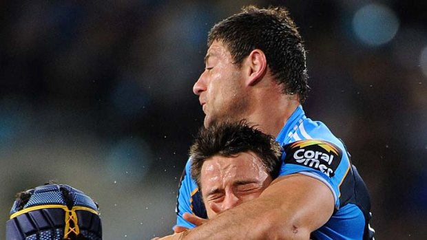 Mark Minichiello of the Titans has Cooper Cronk of the Storm in a loving embrace during the round 23 match.