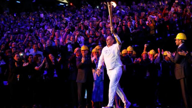 Voice of experience ... Torchbearer Steve Redgrave carries the Olympic flame into the stadium.