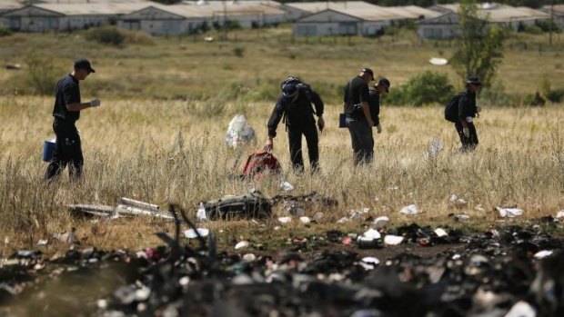 Compensation warning for families of MH17 victims: AFP officers search the crash site. 