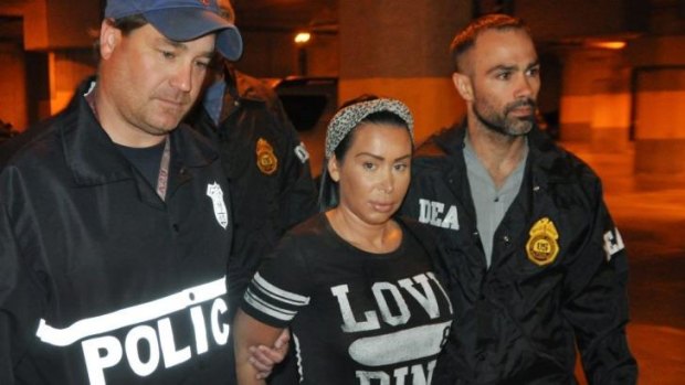 Samantha Barbash, centre, is escorted by police following her arrest in New York. Police allege Barbash is part of a crew of New York City strippers who scammed wealthy men by drugging them before charging extravagant bills.