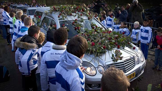 Members of the Dutch soccer club SC Buitenboys place roses on the hearse carrying the body of Richard Nieuwenhuizen.