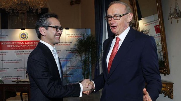 Australian Foreign Minister Bob Carr (right) is greeted by his Indonesian counterpart Marty Natalegawa.