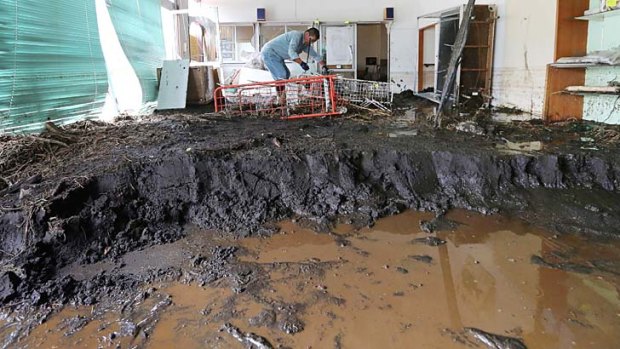 A man scoops out the mud accumulated in his house after a landslide caused by heavy rains from Typhoon Wipha buried houses at Oshima island, 120km south of Tokyo.