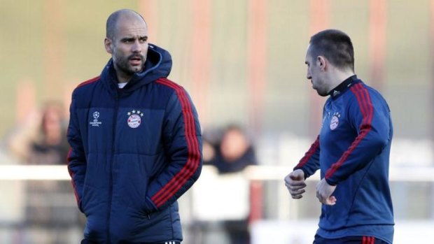 Bayern head coach Pep Guardiola talks to Franck Ribery during a training session in Munich.