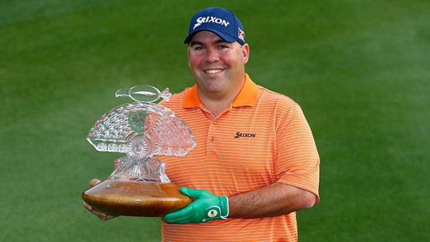 Kevin Stadler poses with the championship trophy after winning the Phoenix Open.