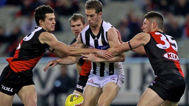 Two on one: Collingwood captain Nick Maxwell is put under pressure by young Bombers Jackson Merrett and Nick O’Brien at the MCG last night.