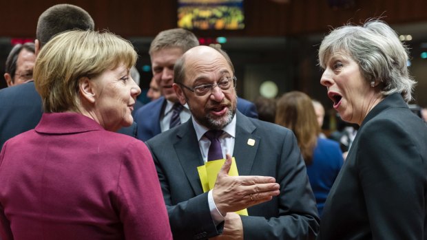 German Chancellor Angela Merkel, left, speaks with British Prime Minister Theresa May, right, and then-European Parliament President Martin Schulz, centre, in Brussels in December 2016.