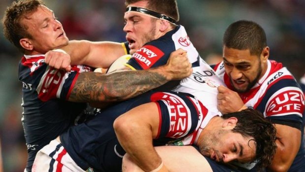 All in: Ethan Lowe of the Cowboys gets to grips with Aidan Guerra of the Roosters.