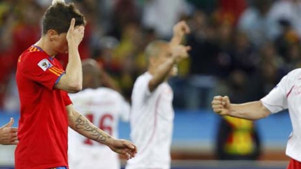 Nightmare ... Spain's Fernando Torres, left, holds his head in his hand at the final whistle as Swiss players celebrate.