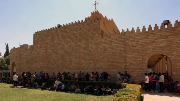 Iraqi Christians who fled the violence in the village of Qaraqush rest upon their arrival at Saint-Joseph's Church in the Kurdish city of Arbil.