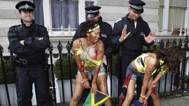 Arresting pose: Dancers have a bit of fun with police officers who were out in full force at the annual Notting Hill Carnival.