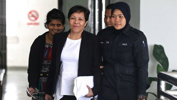 Australian Maria Elvira Pinto Exposto, centre, is escorted by a police officer during a court hearing in Malaysia earlier this month.
