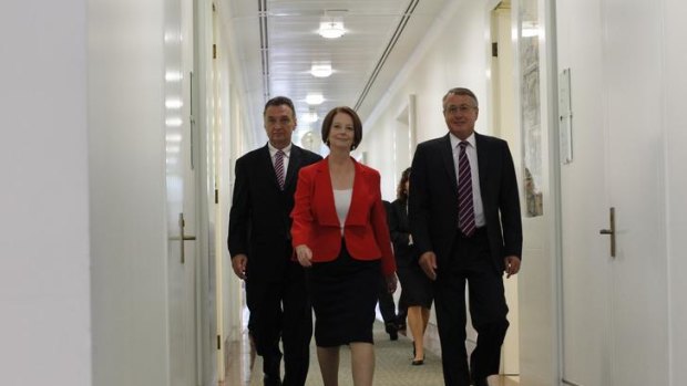 Prime Minister Julia Gillard emerges victorious from the caucus ballot flanked by acting Foreign Minister Craig Emerson (left) and Treasurer Wayne Swan.