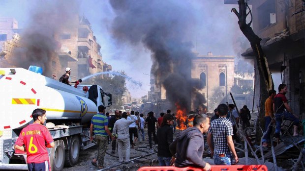 Civil defence workers put out a fire as Syrian citizens gather after an airstrike hit a market in Maaret al-Numan, southern Idlib, Syria, in October.