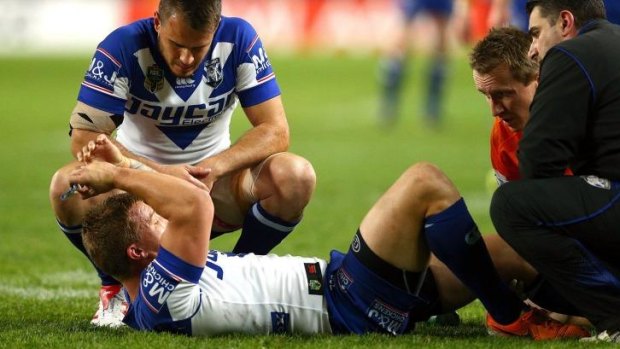 Scare: Medics attend to Trent Hodkinson after he went down having heard a 'pop' in his left knee.