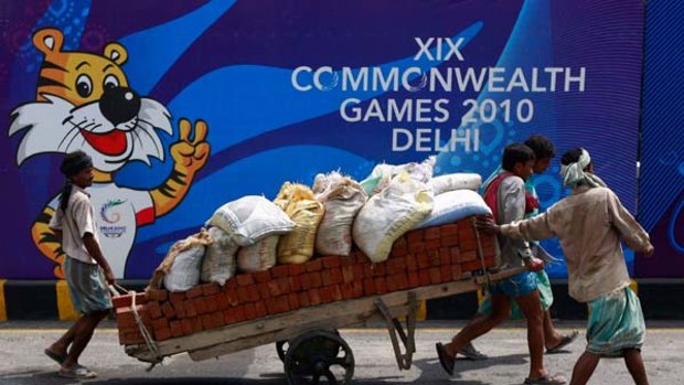 Last-minute preparations ... workers pull a hand cart loaded with bricks and sacks of sand in Delhi. Huge doubts remain over the city's readiness to host the Commonwealth Games.