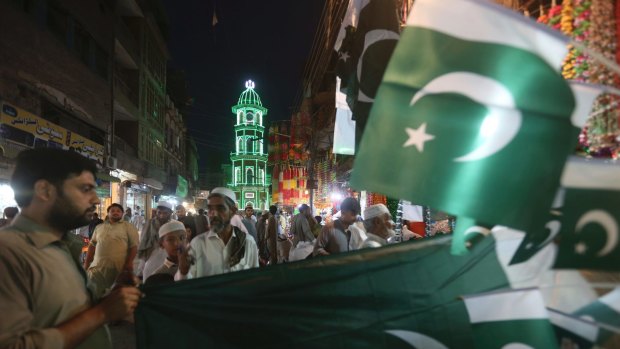 People buy flags to celebrate the Pakistan's Independence Day on Monday, in Peshawar, Pakistan.