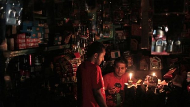 A shopkeeper in Dhaka deals with a customer during the blackout that cut power to the whole of Bangladesh.