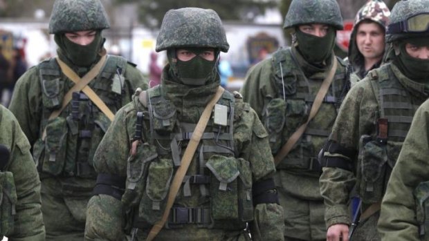 Battle ready: Russian soldiers surround a Ukrainian infantry base in Perevalne on Tuesday.