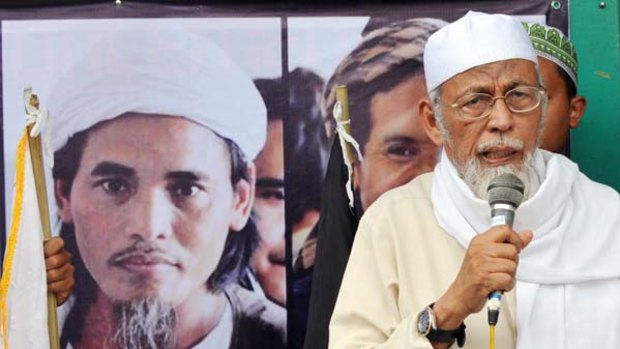 Indonesian cleric Abu Bakar Bashir speaks next to a photo of convicted Bali bomber Amrozi in a file picture.
