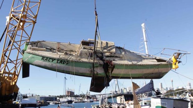 Salvaged ... the hull of Racy Lady is brought ashore in Sydney Harbour. The yacht sank after a collision during the CYC Audi Winter Series in May.