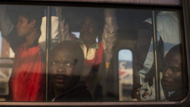 Perilous voyage: Refugees from Nigeria and Ghana wait on a bus to be taken to temporary accommodation after arriving to Sicily.