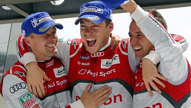Marcel Fassler of Switzerland, Andre Lotterer of Germany, and Benoit Treluyer of France celebrate after winning the Le Mans 24-hour race.