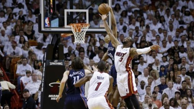 Miami Heat's Dwyane Wade (3) shoots over Charlotte Bobcats' Gerald Henderson.
