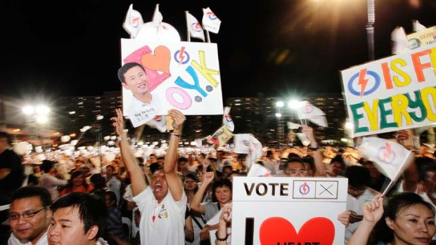 People's Action Party supporters carry signs in support of the Aljunied GRC team, led by the Foreign Minister, George Yeo.
