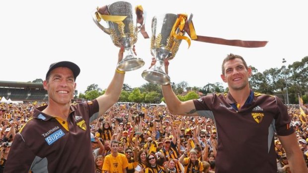 Coach Alastair Clarkson and captain Luke Hodge hold up the 2013 and 2014 premiership cups during the Hawthorn celebrations at Glenferrie Oval on Sunday.