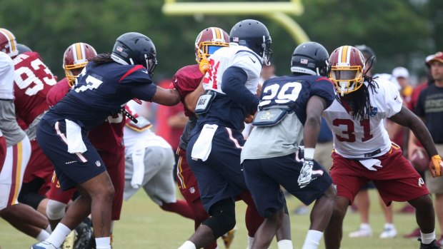 Toe to toe: the Texans and Redskins line each other up in Virginia.