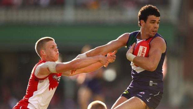 Daniel Hannebery of the Swans tackles Ryan Crowley of the Dockers.
